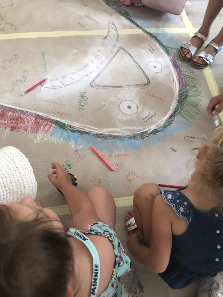 Dziewczynki obok rysunku